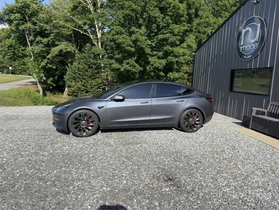 Gray Tesla Model 3 with tinted windows at the NU-Image shop