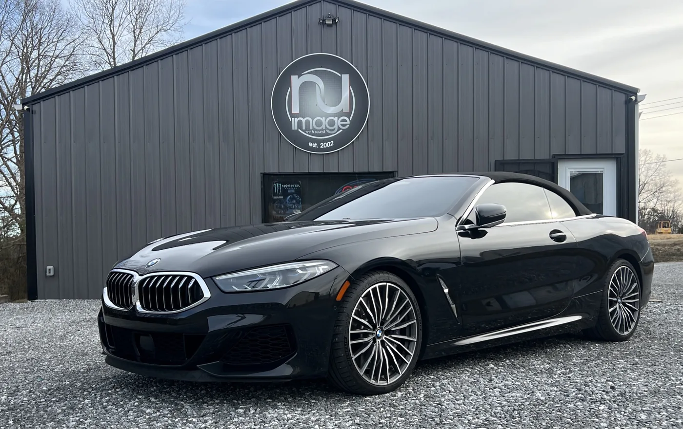 Black BMW 8 Series convertible with tinted glass parked outside the NU-Image shop in Hudson, North Carolina