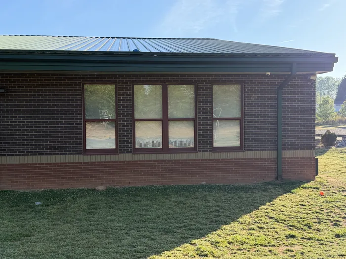 Brick school building with untinted windows, blinds and glare visible from outside